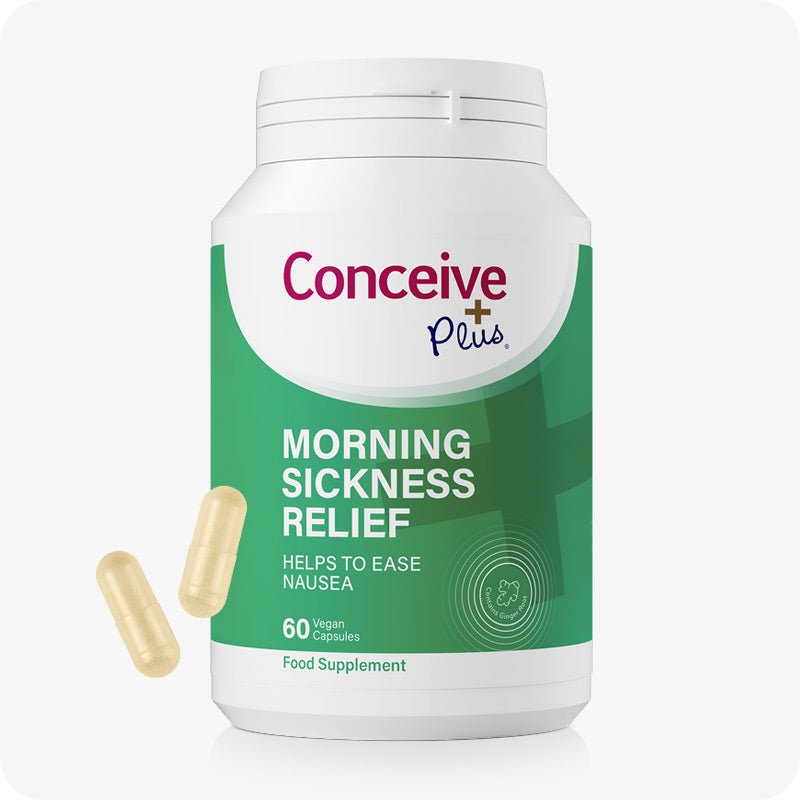 Conceive Plus Morning Sickness Relief supplement bottle with 60 vegan capsules. Green and white label highlights nausea relief benefits with added ginger. Two beige capsules are placed beside bottle to indicate dosage form.