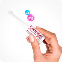 Conceive Plus Fertility Lubricant Pre-Filled Applicators (PT) held by a woman’s hand against a white background. The 4g single-use applicator features bold pink branding and medical symbols, with calcium (Ca) and magnesium (Mg) ion graphics highlighting sperm-friendly ingredients. Designed for ease of vaginal application and fertility support.