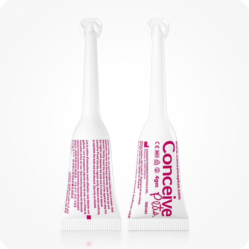 For Conceive Plus Fertility Lubricant Tube + Applicators (PT), close-up of two 4g pre-filled fertility lubricant applicators shown front and back, displaying product branding, CE medical device mark, usage instructions, and manufacturing details printed in pink on white plastic against a white background.