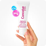 For Conceive Plus Fertility Lubricant Tube + Applicators (PT), image of 75ml fertility lubricant tube held between two fingers with white background, showing product label along with Ca⁺ and Mg⁺ ion graphics, highlighting calcium and magnesium formula designed to support fertility.