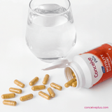 Conceive Plus motility support capsules with a glass of water on a white background